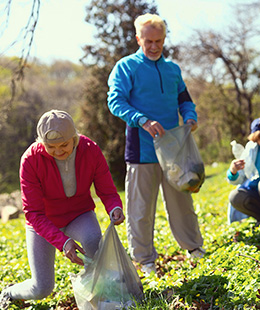 People in community picking up litter on hillside